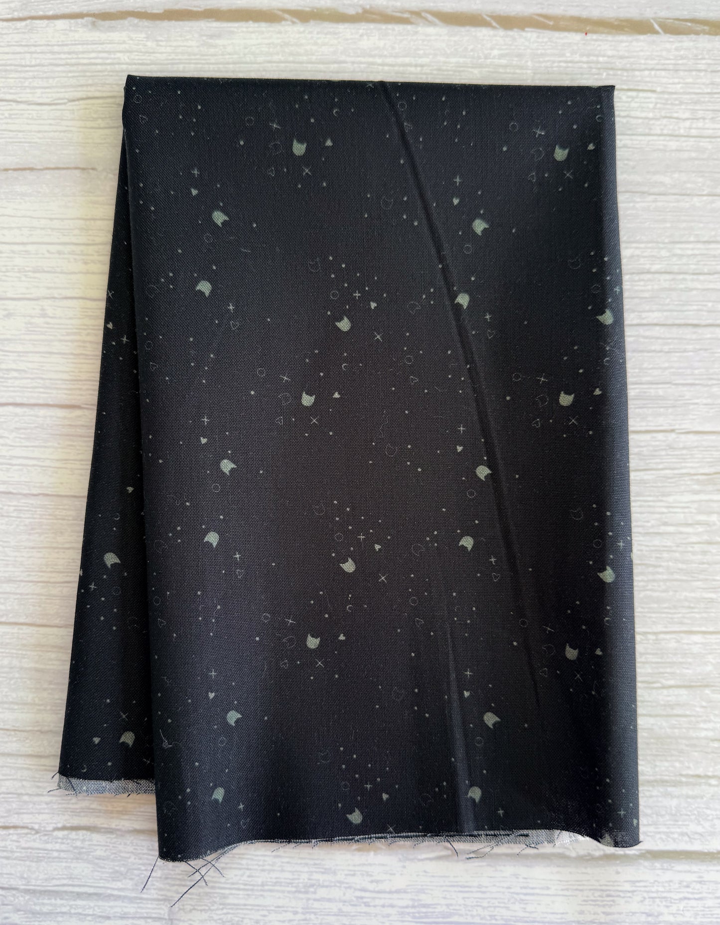 Black fabric with gray speckles on a wood surface