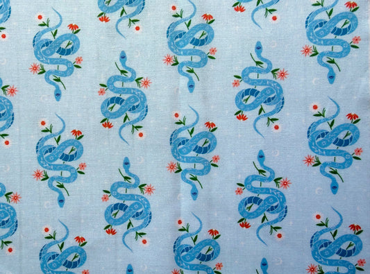 Pattern of blue snakes and flowers on a light blue background