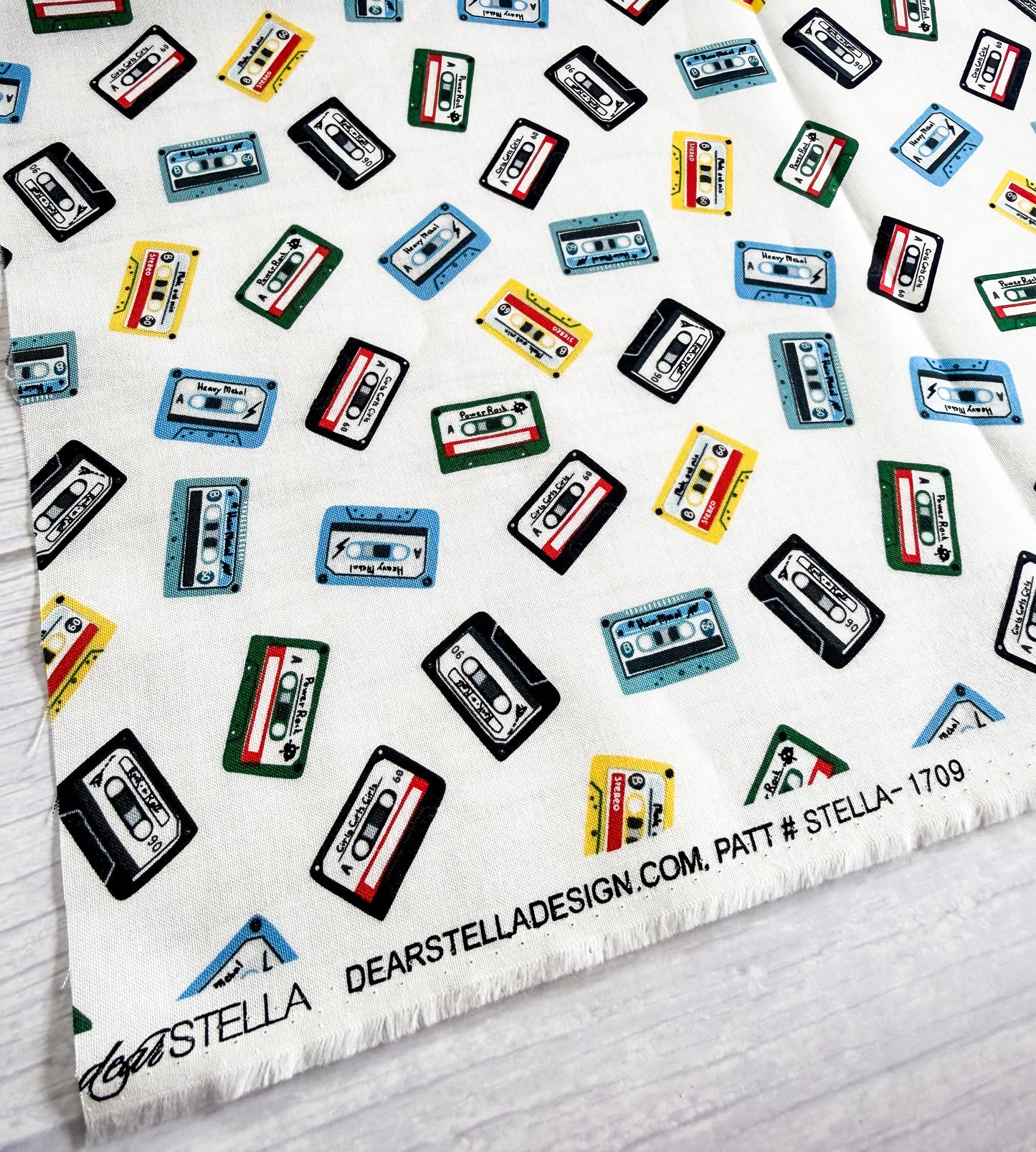 Cassette tape patterned fabric with 'Dear Stella' branding on a white background
